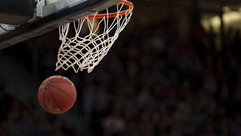 NBA篮球赛事精彩瞬间，运动员腾空扣篮，球馆灯光璀璨，观众欢呼沸腾